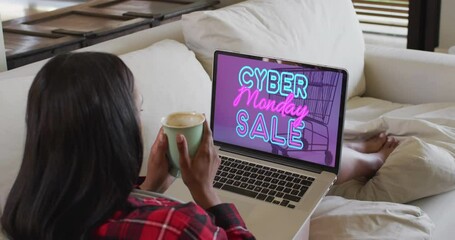 Poster - Biracial woman using laptop at home for online shopping, slow motion
