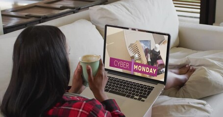Poster - Biracial woman on couch using laptop for online shopping, slow motion