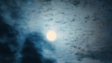Wall Mural - full luminous moon with clouds dispersed by wind at night. bright moon moving across the sky covered