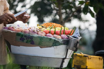 Indian street food vendor preparing and selling fresh bhelpuri in the street.