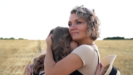 a smiling mother hugs her daughter, close-up