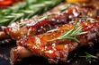 close-up of glazed pork ribs with fresh rosemary on top