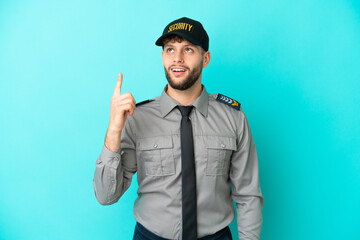 Wall Mural - Young security man isolated on blue background pointing up and surprised