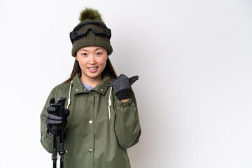 Wall Mural - Young Chinese woman wearing winter jacket isolated on white background pointing to the side to present a product