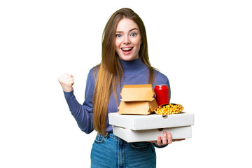 Poster - Young pretty woman holding pizzas and burgers over isolated chroma key background celebrating a victory in winner position