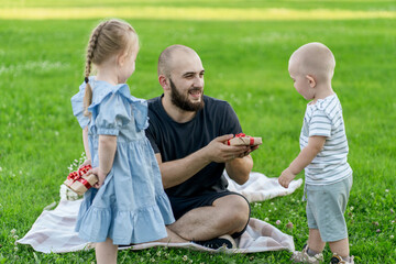 Wall Mural - father presenting gifts to his little kids on a birthday