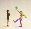 © Westend61 - Illustration of serious woman looking at foolish jester