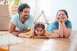 © Westend61 - Happy parents with daughter holding model house on floor