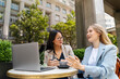 © Westend61 - Businesswoman discussing with partner at sidewalk cafe