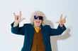 © Westend61 - Happy senior man showing horn gesture against white background