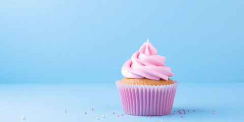 Wall Mural - pink cupcake isolated on blue background with copy space