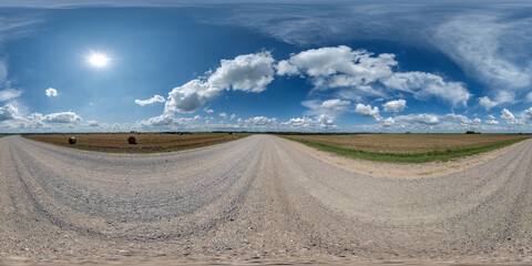Wall Mural - 360 hdri panorama on gravel road with marks from car or tractor tires with clouds on blue sky in equ