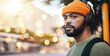 © Malambo C/peopleimages.com - Bokeh, music headphones and man thinking outdoor, listening to audio or sound on internet in city to travel. Radio, streaming podcast and serious person hearing online media for freedom in urban town