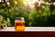 © Oranuch - Honey jar on table with nature background