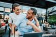 © Dusko - Handsome and happy father and his teenager son sitting in a restaurant and talking.