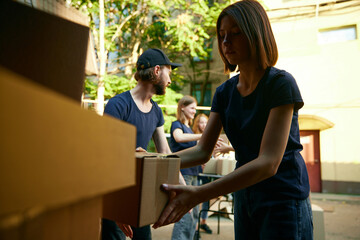 Young people, volunteers loading boxes into van. Gathering food, clothes and meds for people and animals in need. Concept of humanitarian aid, assistance and support, care, social programs