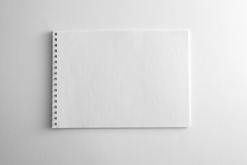 Mockup of white book, notebook, copybook, blank notepad cover with metal spiral template on white background. Layout mock up ready for your design preview.