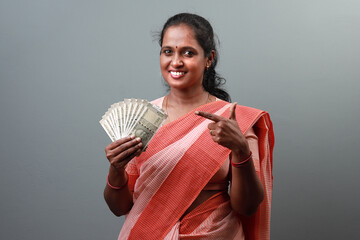 Happy Indian woman holding Indian currency notes in hand