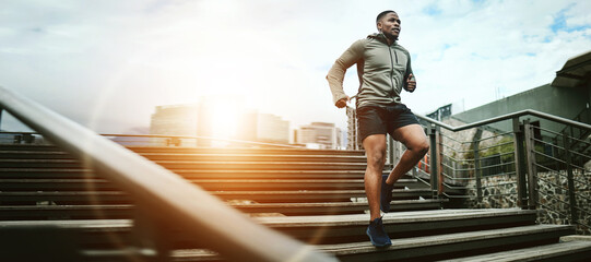 Wall Mural - Fitness, city and black man running on steps outdoor, exercise and training healthy body in the morning at sunrise. Sports, cardio and African athlete on stairs for workout, wellness and lens flare