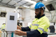 © amorn - Male engineer worker control CNC machine at the industry factory. Male technician inspecting quality of machine in the factory