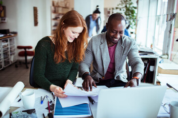 Young man and woman working together on a project in a startup company office