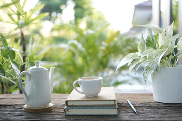 Wall Mural - white tea cup and tea pot and plant pot and notebook on wooden tray and table balcony outdoor view