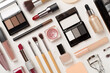 Flat lay with makeup products and tools on concrete background
