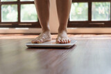Fototapeta Panele - Fat diet and scale feet standing on electronic scales for weight control. Measurement instrument in kilogram for a diet control