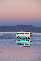 Wall Mural - Perfect reflection of a classic van on a salt flat with water at sunset