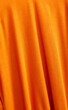 Draped orange fabric detail.Fashion background