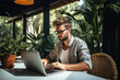© somsuda - Freelance young man working sitting on table using laptop computer.