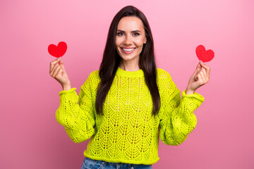 Sticker - Photo of adorable pretty girl with long hairstyle dressed yellow sweatshirt hold small paper hearts isolated on pink color background