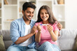 © Prostock-studio - Excited indian couple looking at positive pregnancy test, smiling and enjoying great news, sitting on couch at home