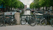 Rowery miejskie zaparkowane na moście przechodzącym przez kanał w jednej z dzielnic Amsterdamu.
