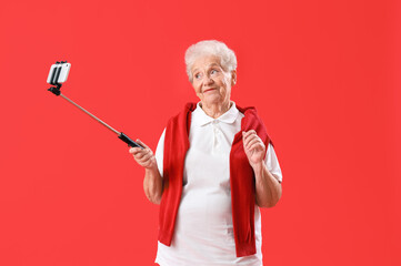 Sticker - Senior woman with mobile phone on red background