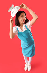 Poster - Happy young beautiful Asian woman with colander on red background