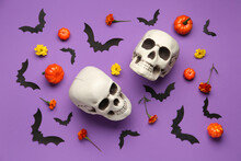 Halloween Composition With Skulls, Paper Bats, Pumpkins And Marigold Flowers On Purple Background