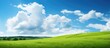 Leinwandbild Motiv Green grass slope with blue sky and clouds
