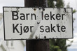 Sign in the Norwegian language with translated text promt drivers that Children play - Drive slowly.