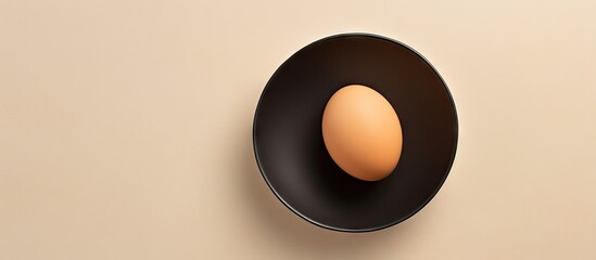 Aufkleber - Shell less raw egg on black plate on a isolated pastel background Copy space