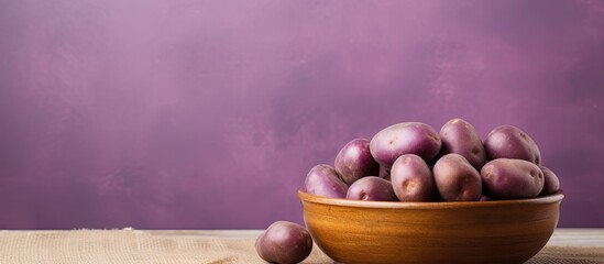 Aufkleber - Top view of isolated purple potatoes in wooden bowl isolated pastel background Copy space