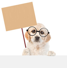 Poster - Funny smart Golden retriever puppy wearing eyeglasses shows empty placard above empty white banner. isolated on white background