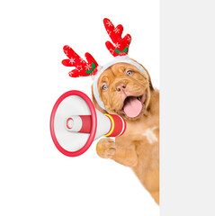 Poster - Happy Mastiff puppy dressed like santa claus reindeer  Rudolf looks from behind empty white banner and barks into megaphone. isolated on white background
