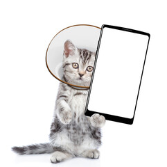 Poster - Cute tabby kitten with protective cone collar on her neck  shows big smartphone with empty screen. Isolated on white background