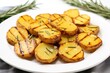 grilled potatoes garnished with rosemary on a white plate