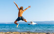 Young boy,  happy child jumping in the air on the beach- vacation, happiness, travel destination concept