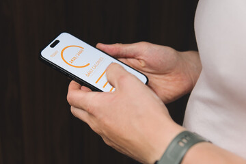 an athletic man holds a smartphone with a calorie counting application in his hand