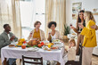 © LIGHTFIELD STUDIOS - multicultural friends celebrating Thanksgiving with lgbt family and toddler baby girl, gathering