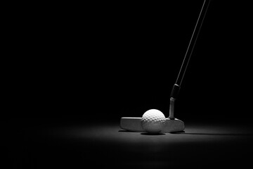 Golf Putter and Ball Spotlit on a Black Background with Copy Space