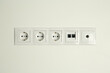 © New Africa - Many power sockets with ethernet and TV coax plates on white wall indoors